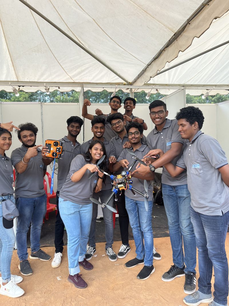 Team of twelve with their drone under a competition marquee