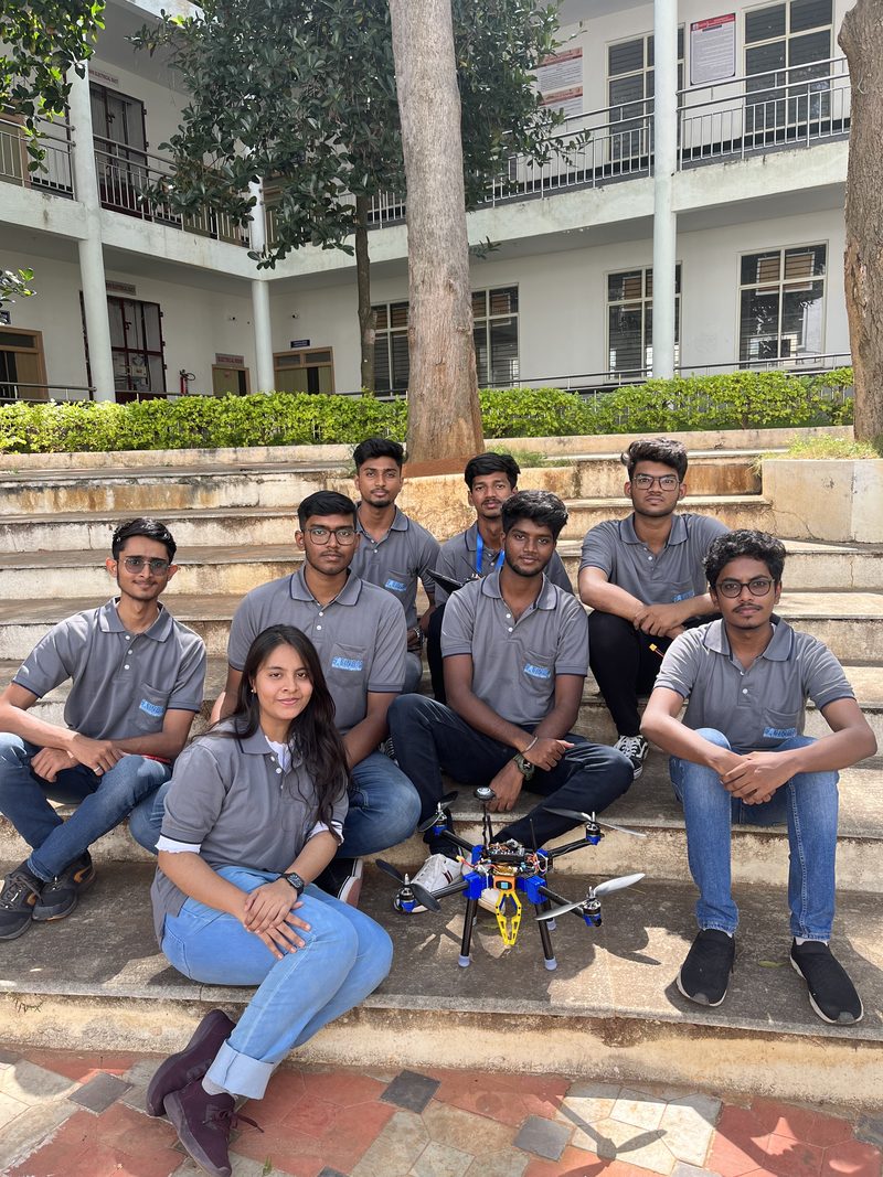 Team Delta members seated on steps with their multirotor drone