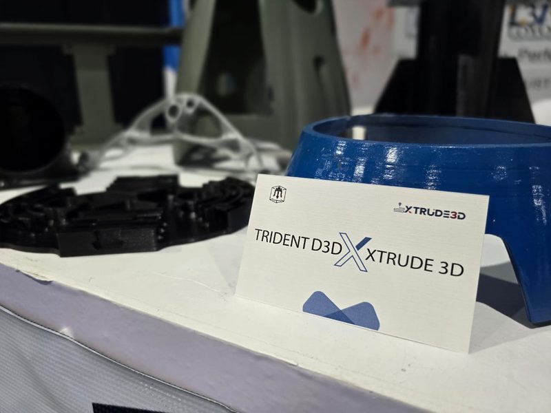 3D-printed parts next to an XTRUDE3D business card